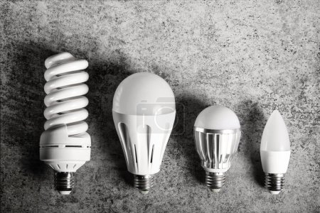 Photo for Top view of 4 different e27 household light bulbs on a gray background. - Royalty Free Image