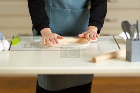 Foto de Cooking dough products on a large kitchen table on a kitchen silicone mat with copy space. - Imagen libre de derechos
