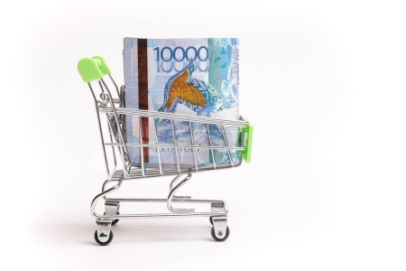 Téléchargez les photos : 10000 Kazakhstani tenge in a shopping cart isolated on white background. - en image libre de droit
