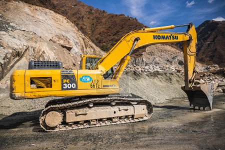 Photo for Komatsu PC300 yellow excavator in Almaty mountains involved in the construction of the dam. Almaty, Kazakhstan - September 28, 2022 - Royalty Free Image