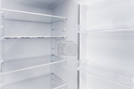 Téléchargez les photos : Réfrigérateur vertical blanc vide neuf avec étagères. - en image libre de droit