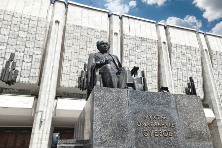 Foto de Fachada Teatro Nacional de Drama de Kazajstán. M. Auezov con una escultura de Auezov delante de él. Almaty, Kazajstán - 08 de mayo de 2023 - Imagen libre de derechos