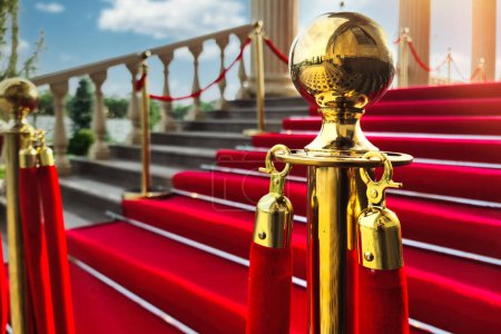 Foto de La alfombra roja en la gran escalera para VIPs con una barrera de cinta roja en primer plano. - Imagen libre de derechos