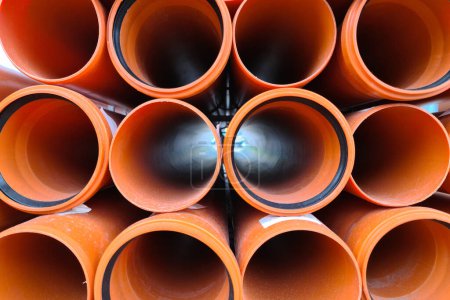 Foto de Montones de nuevos tubos de alcantarillado naranja con juntas, 100mm. - Imagen libre de derechos