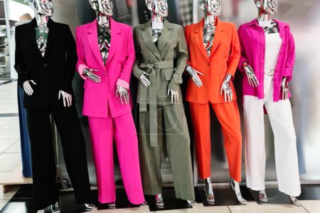 Colorful womens clothing in a boutique is worn on mannequins.