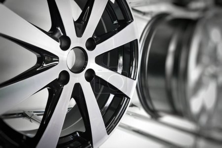 Close-up of light alloy wheels designed for passenger cars on display at a store stand.