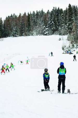 Foto de Ski instructor and kids at ski school, in Poland Karpathians. Forest in the background. - Imagen libre de derechos