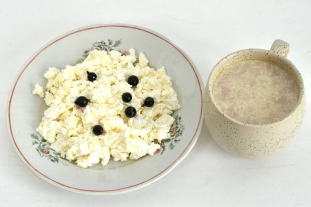 Foto de Un plato de requesón y una taza de cacao, un delicioso y saludable desayuno. - Imagen libre de derechos