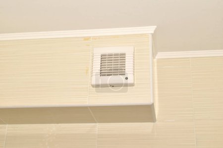 Téléchargez les photos : Système de ventilation, une boîte doublée de tuiles et un ventilateur monté sur la boîte. Salle de bain. - en image libre de droit