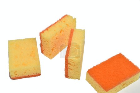 Orangefarbene Küchenschwämme liegen chaotisch auf weißem Hintergrund.