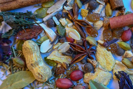Photo for Close-up of a vegetable mixture consisting of nuts, raisins, cinnamon sticks, cloves, ginger, pepper, pumpkin seeds, salt,cardamom,cumin  bay leaves and various dried herbs. - Royalty Free Image