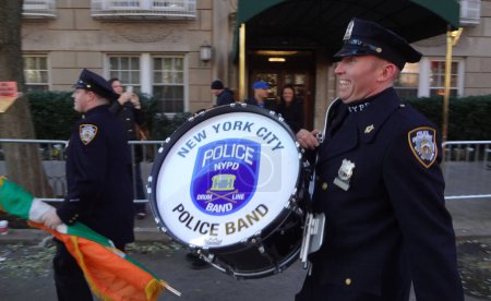 Foto de NUEVA YORK CITY-23 DE NOVIEMBRE DE 2017: Un orgulloso miembro de la Banda del Departamento de Policía de la Ciudad de Nueva York, Drum Line Unit, es visto llevando su tambor mientras se prepara para marchar en el Desfile del Día de Acción de Gracias de Macy 's 2017 - Imagen libre de derechos