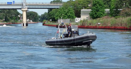 Photo for POINT PLEASANT CANAL-POINT PLEASANT BEACH, NEW JERSEY, USA-AUGUST 31, 2023: A New Jersey State Police Officer (Marine Bureau) is seen on patrol using his rigid hull inflatable boat at the start of the long Labor Day Weekend. - Royalty Free Image