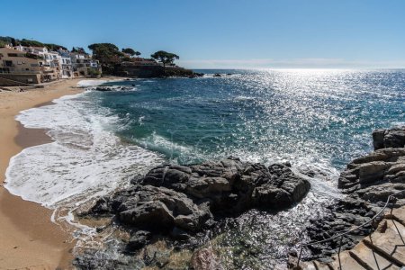 Küstenlandschaft an einem sonnigen Tag an einem Strand an der Costa Brava, Katalonien mit Sonnenstrahlen am blauen Himmel