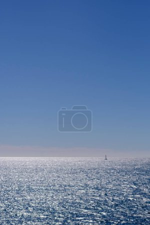 Tiny boat sailing on quiet blue waters in Mediterranean Sea summer beach holidays blue seascape