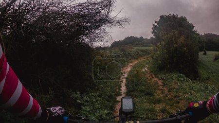Montar en bicicleta de montaña en una sola pista fangosa en un bosque de paisaje lluvioso en el bosque