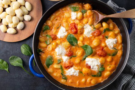 Téléchargez les photos : Casserole de gnocchi à la sauce tomate crémeuse aux épinards et mozzarella fondue - en image libre de droit