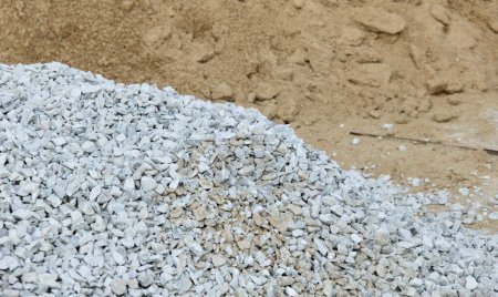 Foto de Una fotografía de una pila de grava y grava junto a una pila de arena, hay una pila de grava y grava en el suelo - Imagen libre de derechos