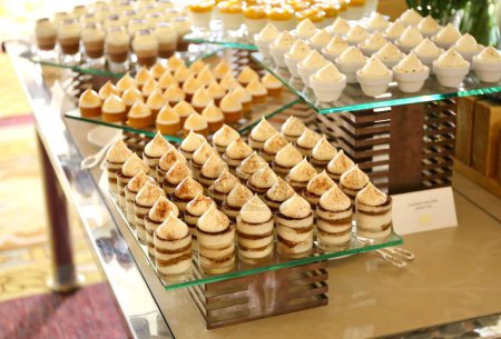 Téléchargez les photos : Une photographie de desserts de boulangerie exposés sur des étagères en verre dans un restaurant. - en image libre de droit