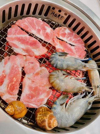 Foto de Una fotografía de una cesta de camarones y carne de camarón en una parrilla, hay muchos camarones y camarones cocinando en una parrilla. - Imagen libre de derechos