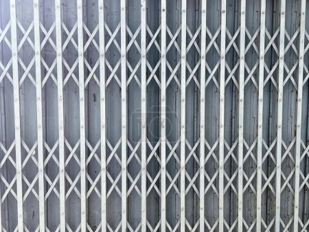 Téléchargez les photos : Une photographie d'une clôture métallique blanche avec un motif de carrés, un gros plan d'une porte métallique avec un motif dessus. - en image libre de droit