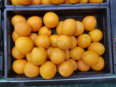 Téléchargez les photos : Une photographie d'un couple de caisses remplies d'oranges, il ya beaucoup d'oranges dans les bacs sur la table. - en image libre de droit