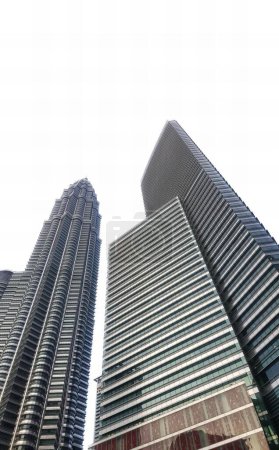 Foto de Una fotografía de un par de edificios altos con un fondo de cielo, edificios altos en una ciudad con un reloj en la parte superior. - Imagen libre de derechos
