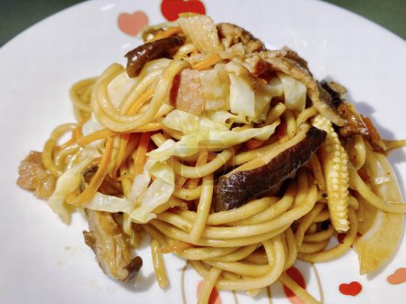 Foto de Una fotografía de un plato de pasta con setas y otros alimentos, hay un plato de pasta con carne y verduras en él. - Imagen libre de derechos