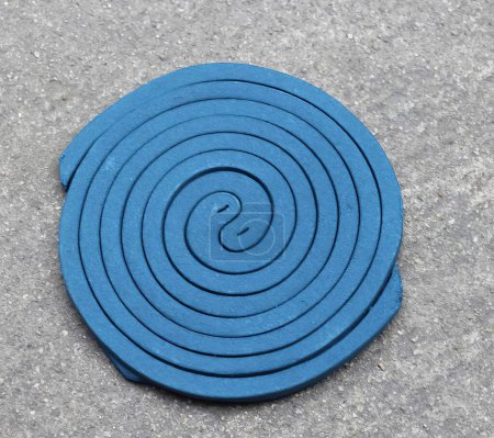 Photo for A photography of a blue coaster with a spiral design on it, a close up of a blue circular object on a concrete surface. - Royalty Free Image