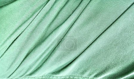 Téléchargez les photos : Une photographie d'un tissu vert avec une très longue ligne de plis, tissu vert abaya avec un léger motif. - en image libre de droit