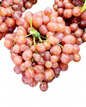 Foto de Una fotografía de un racimo de uvas sobre un fondo blanco, cesto uvas están dispuestas en forma de corazón sobre una superficie blanca. - Imagen libre de derechos