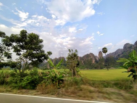 Foto de Una fotografía de una vista panorámica de un campo y montañas, valle con hierba verde y árboles en un día soleado. - Imagen libre de derechos