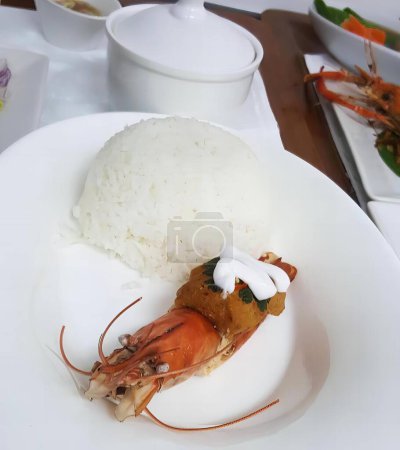 Foto de Una fotografía de un plato de comida con arroz y camarones, plato de comida con camarones y arroz sobre una mesa con tazones de verduras. - Imagen libre de derechos