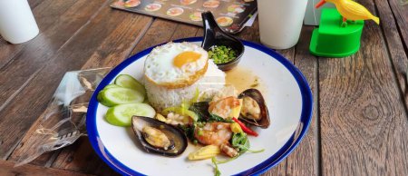 Téléchargez les photos : Photographie d'une assiette de nourriture avec riz, musselling et crevettes, assiette de nourriture sur une table avec une boisson et une fourchette. - en image libre de droit