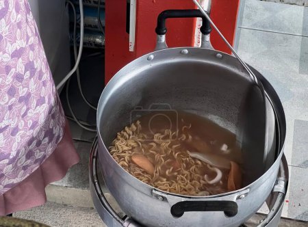 Foto de Una fotografía de una olla de fideos que se cocina en una estufa, caldero de fideos en una olla en una estufa. - Imagen libre de derechos