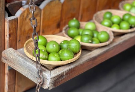 una fotografía de un estante de madera con cestas de manzanas verdes, manzanas verdes de la abuela en cestas en un estante de madera.