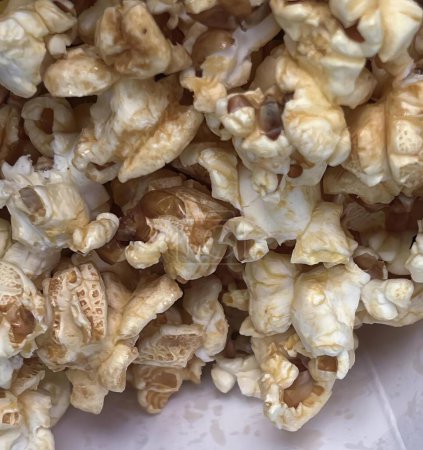 Téléchargez les photos : Une photographie d'un tas de pop-corn assis sur une table blanche, polyporus frondosus popcorn est une collation qui n'est pas trop sucrée. - en image libre de droit