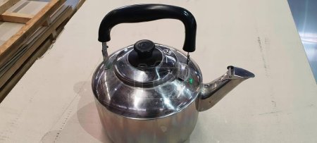 Photo for A photography of a tea kettle sitting on a table in a warehouse, water jug on a table with a handle and a handle. - Royalty Free Image