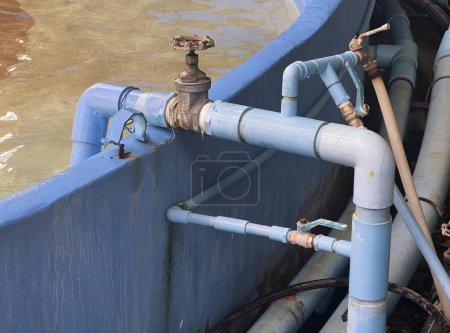 Téléchargez les photos : Une photographie d'un bateau bleu avec des tuyaux et des vannes dans l'eau, des tuyaux et des vannes de style sous-marin sont connectés à un bateau bleu. - en image libre de droit