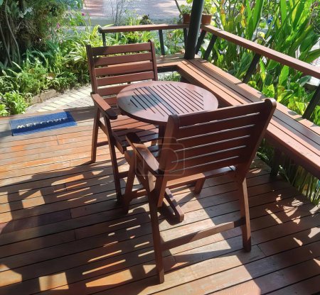 Foto de Una fotografía de una mesa de madera y sillas en una cubierta, terraza con muebles de madera y una mesa en un día soleado. - Imagen libre de derechos