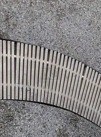 Photo for A photography of a curved metal grate on a sidewalk, pandean pipe grate on the ground with a person walking on it. - Royalty Free Image
