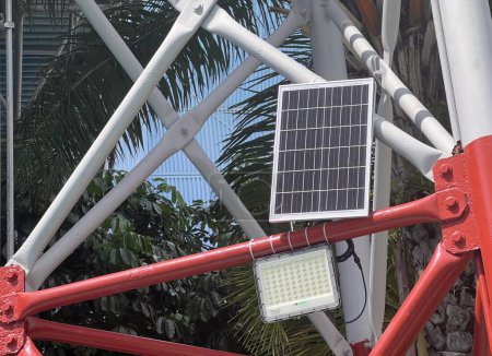 Photo for A photography of a solar panel mounted on a red bicycle, solar collector on a red bicycle with a palm tree in the background. - Royalty Free Image