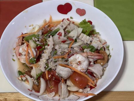 Foto de Una fotografía de un tazón de comida con una decoración en forma de corazón, plato de comida con carne, verduras y salsa en una mesa. - Imagen libre de derechos