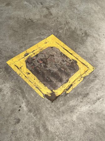 Téléchargez les photos : Une photographie d'un panneau carré jaune sur un sol en béton. - en image libre de droit