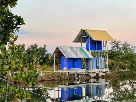 Téléchargez les photos : Une photographie d'un couple de maisons assises au sommet d'un lac. - en image libre de droit