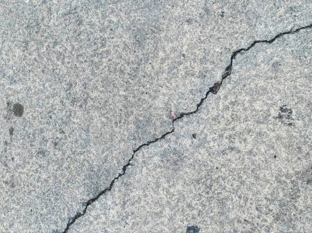 a photography of a crack in the concrete shows a crack in the ground.