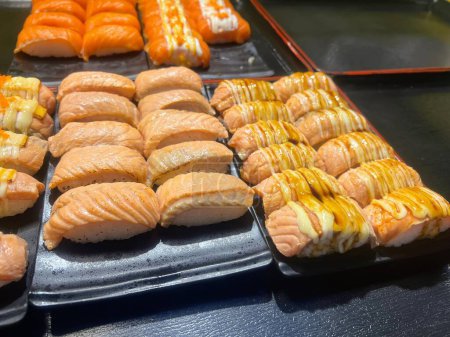 una fotografía de un buffet con una variedad de sushi y rollos.
