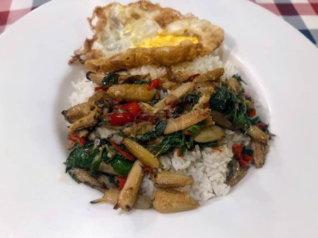 una fotografía de un plato de comida con arroz y verduras.