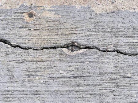 a photography of a crack in a concrete wall with a heart shaped hole.