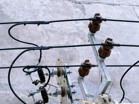 una fotografía de una línea eléctrica con múltiples cables y un poste de teléfono.